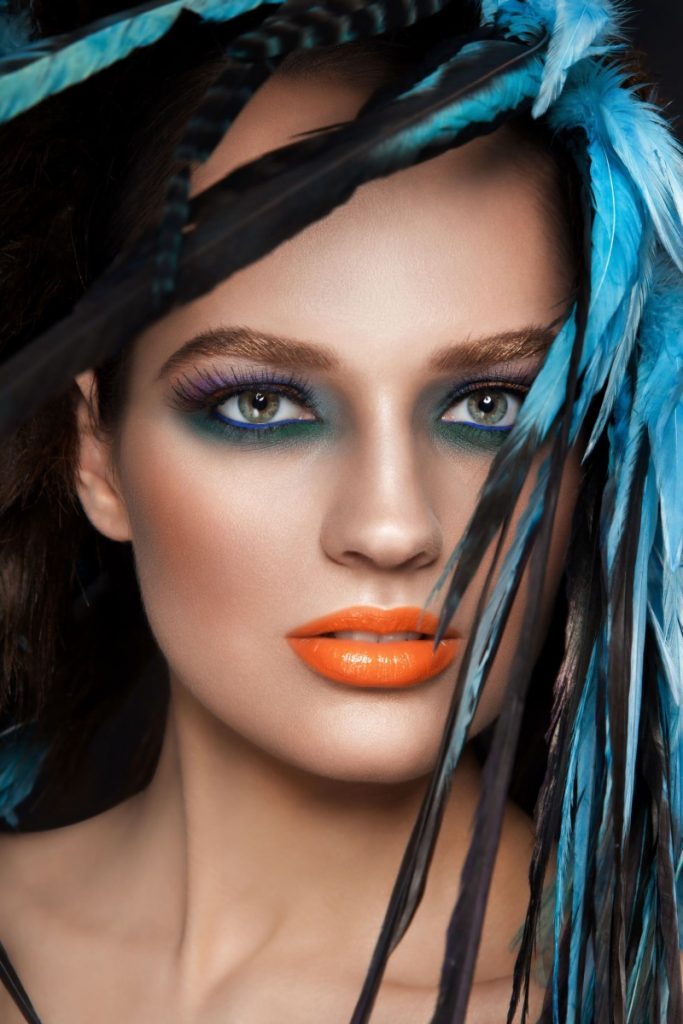 Frau mit blauen Federn im Haar